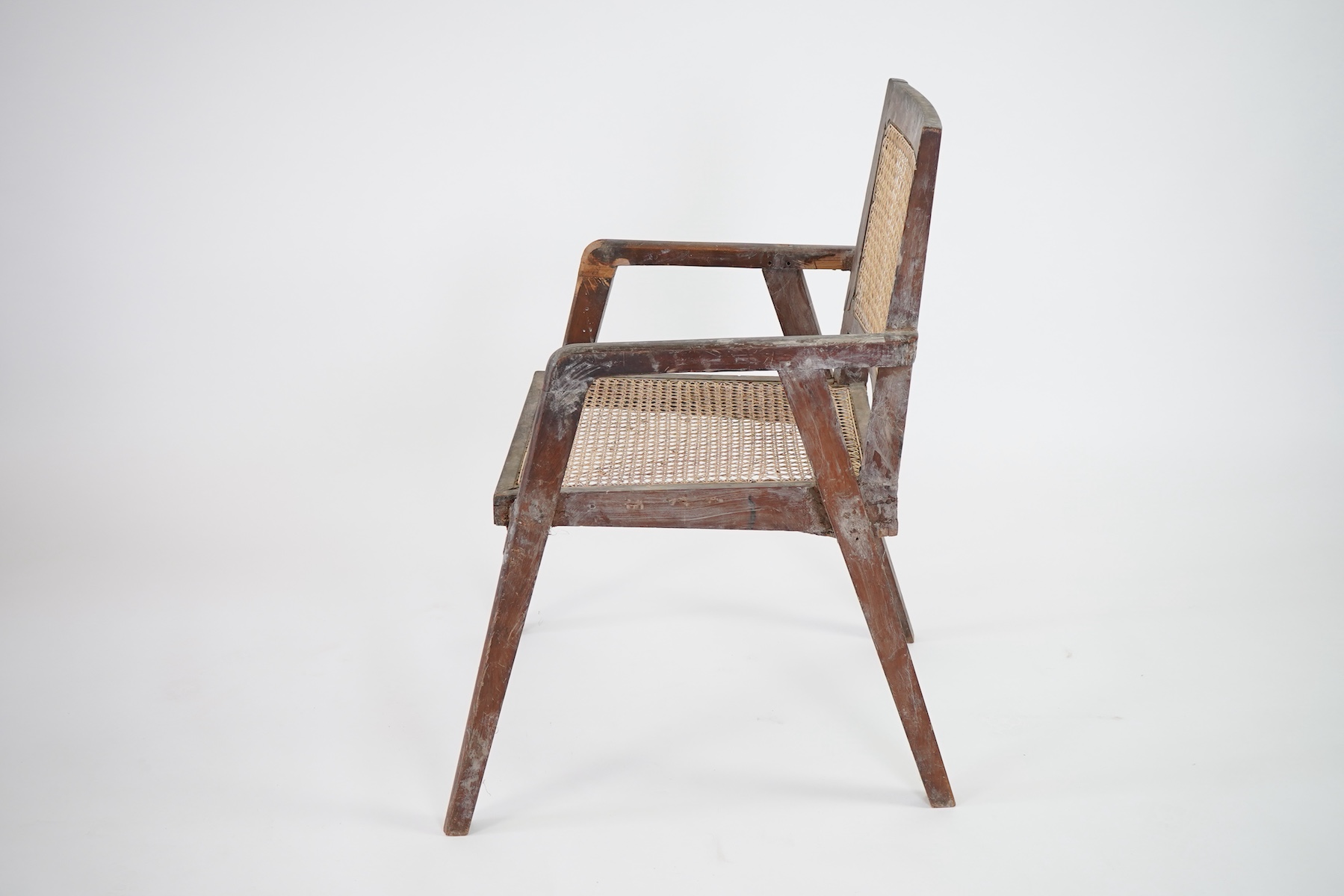 Manner of Pierre Jeanneret (Swiss, 1896-1967): A solid teak and braided canework armchair